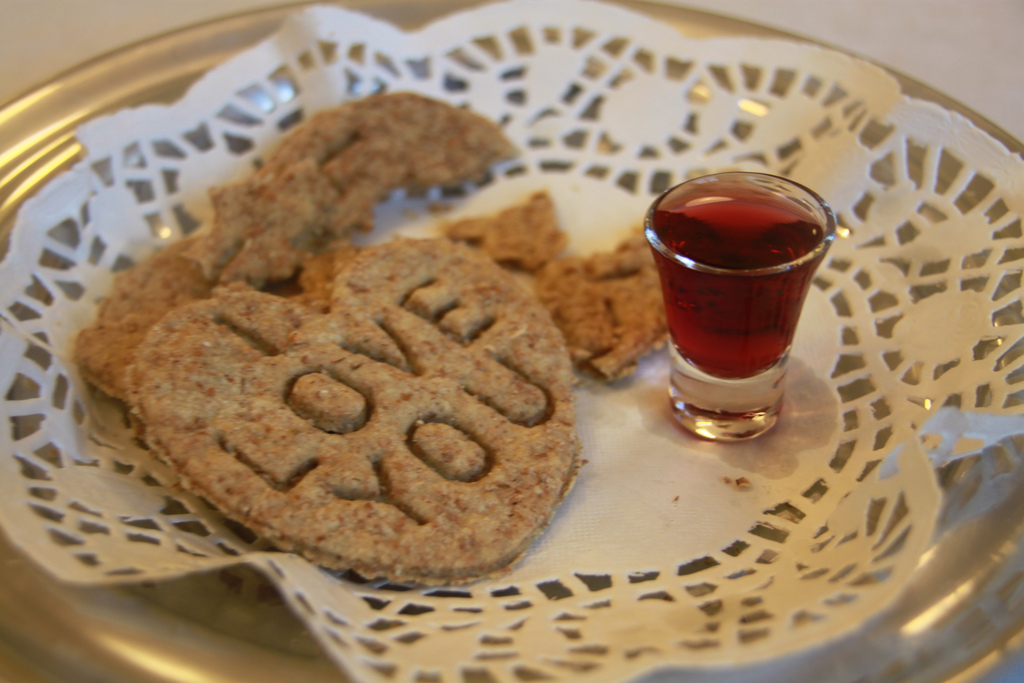 Heart shaped communion bread on lace with grape juice